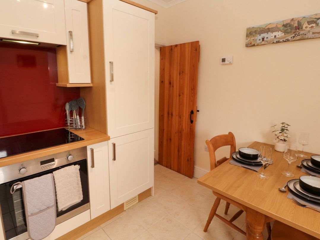 A kitchen with cabinets and a dining table at Tethera in Ennerdale