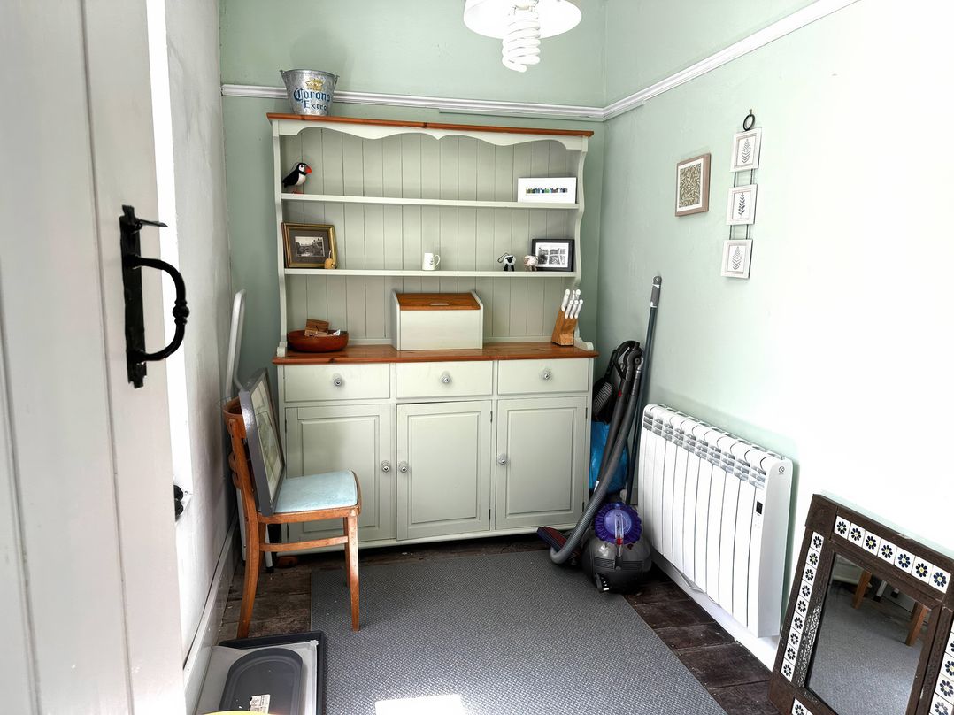 A hallway with a shelf and vacuum cleaner at Glanrafon in Llwyngwril
