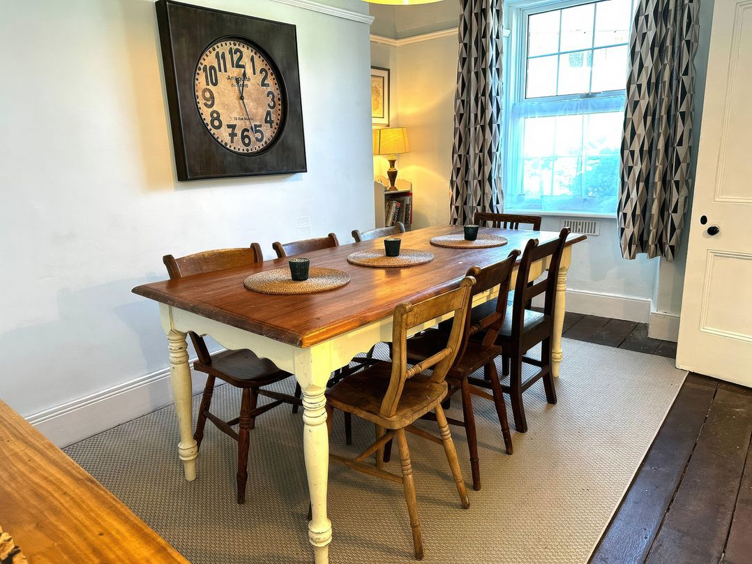 A dining room with a large table and chairs at Glanrafon in Llwyngwril