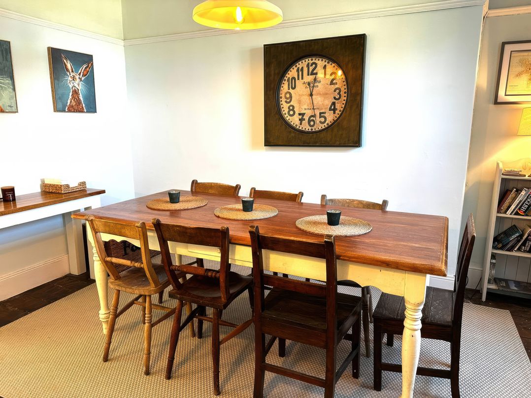 A dining room with a table and chairs at Glanrafon in Llwyngwril