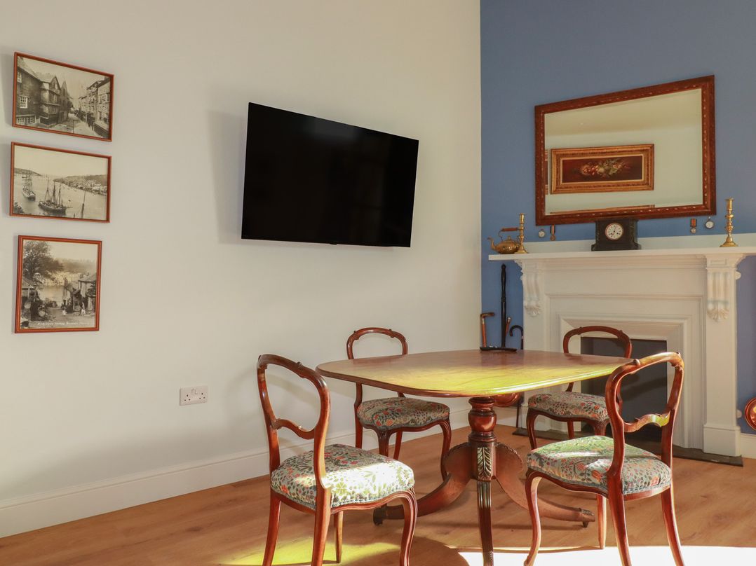 A dining room with a table and chairs at Farthings, The Old Chapel in St Austell