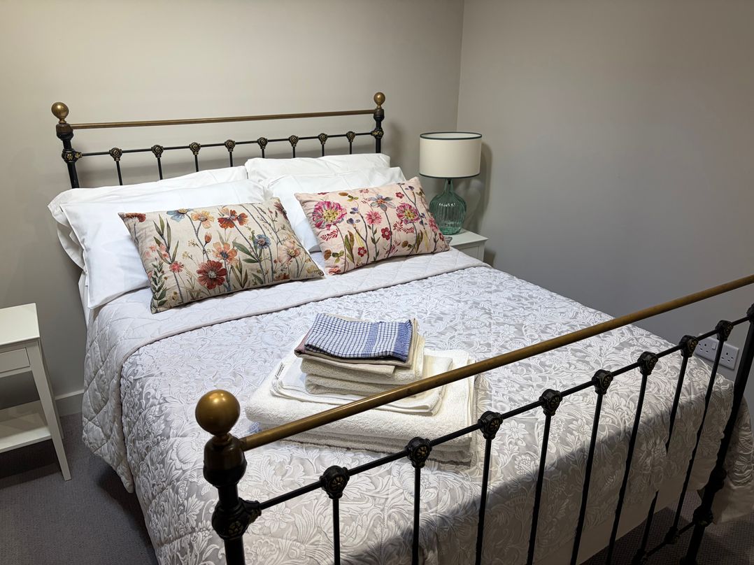 A bedroom with a bed and pillows at The Cottage at Thorpe Farm in Appleton-le-Moors near Kirkbymoorside