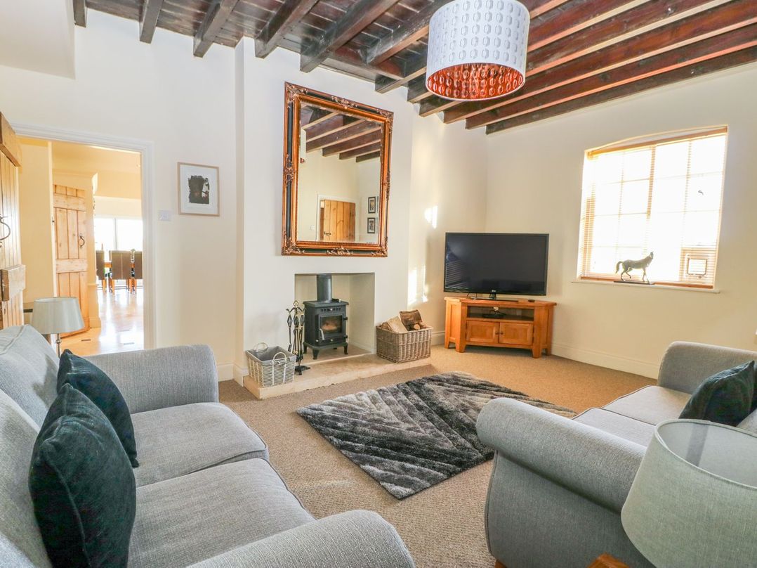 A living room with a television and sofa at Tuft House in Hovingham