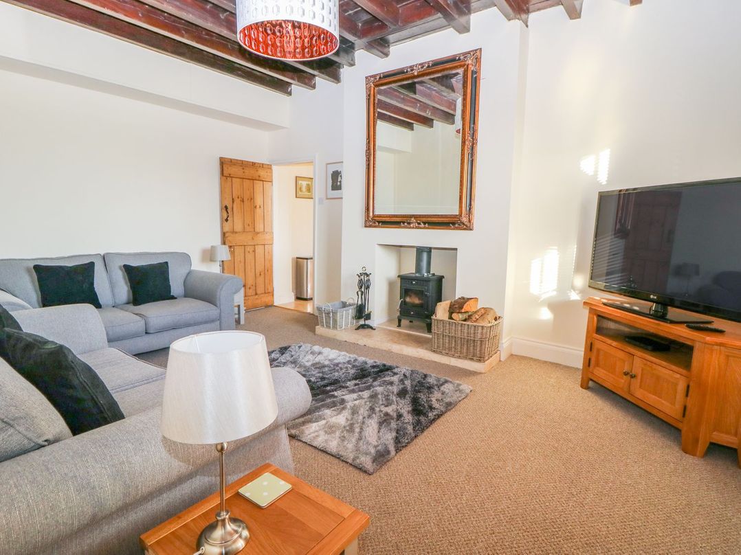 A living room with a television and fireplace at Tuft House Hovingham