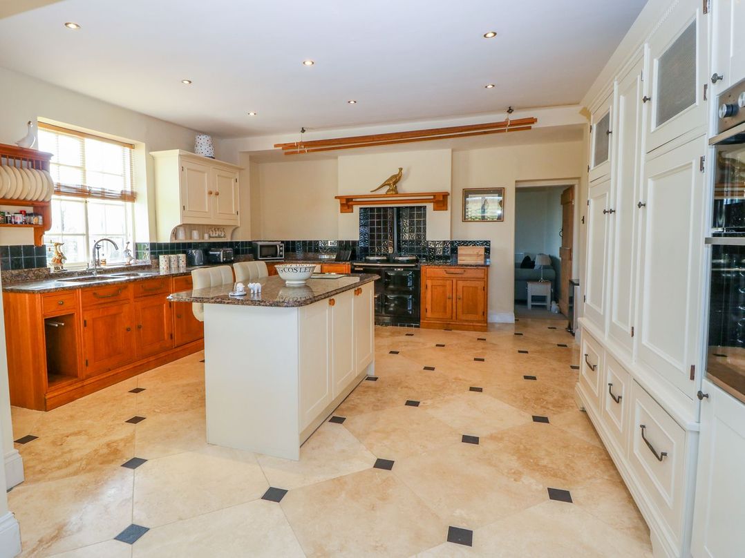 A kitchen with a central island and cabinets at Tuft House in Hovingham