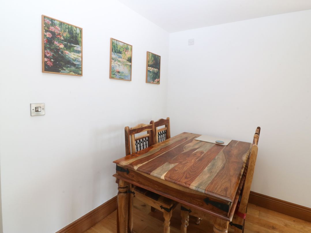 A dining room with a wooden table and chairs at Apartment 1, Bryn Mel Manor in Menai Bridge