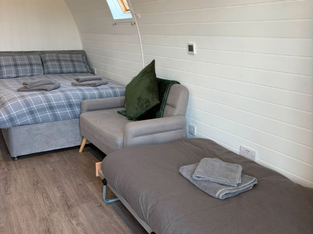 A bedroom with a bed and chair at Natures Nest near Rillington