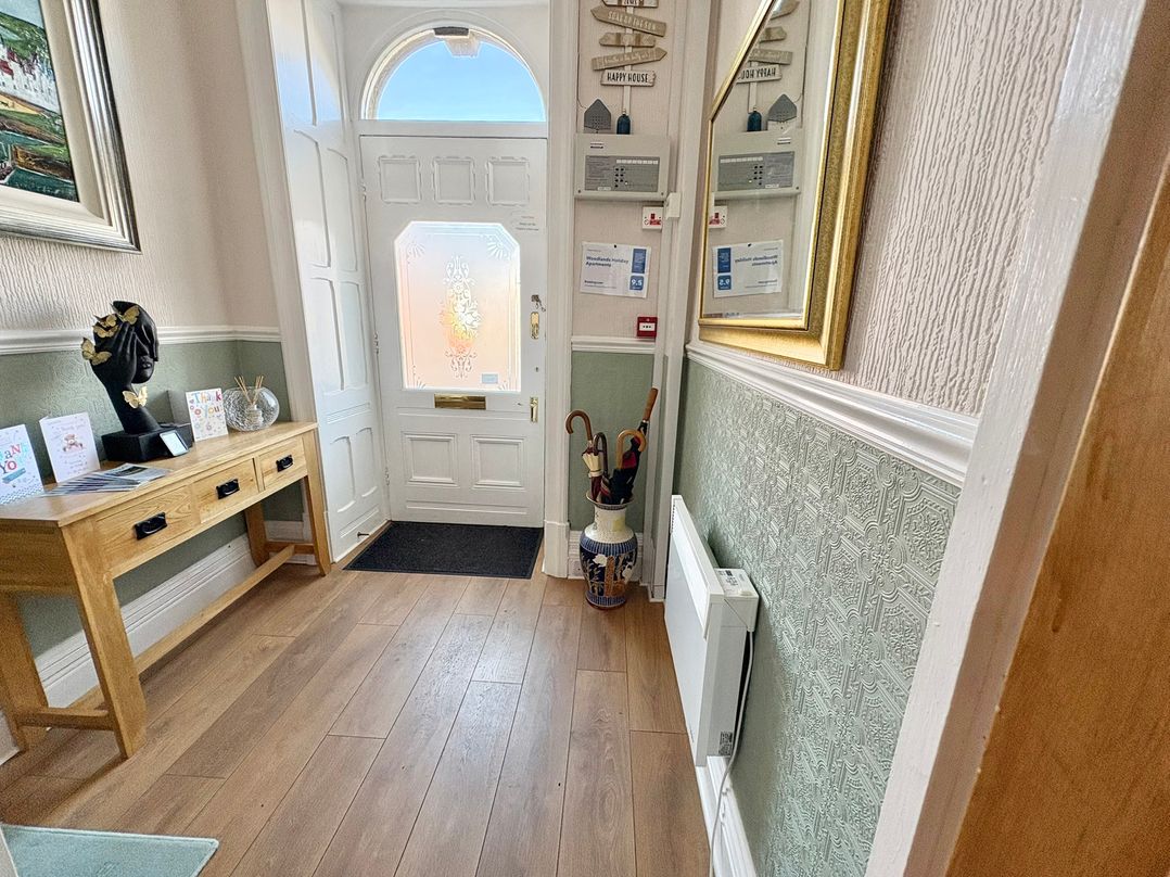 A hallway with a console table and door at Apartment 3 Lytham St. Annes