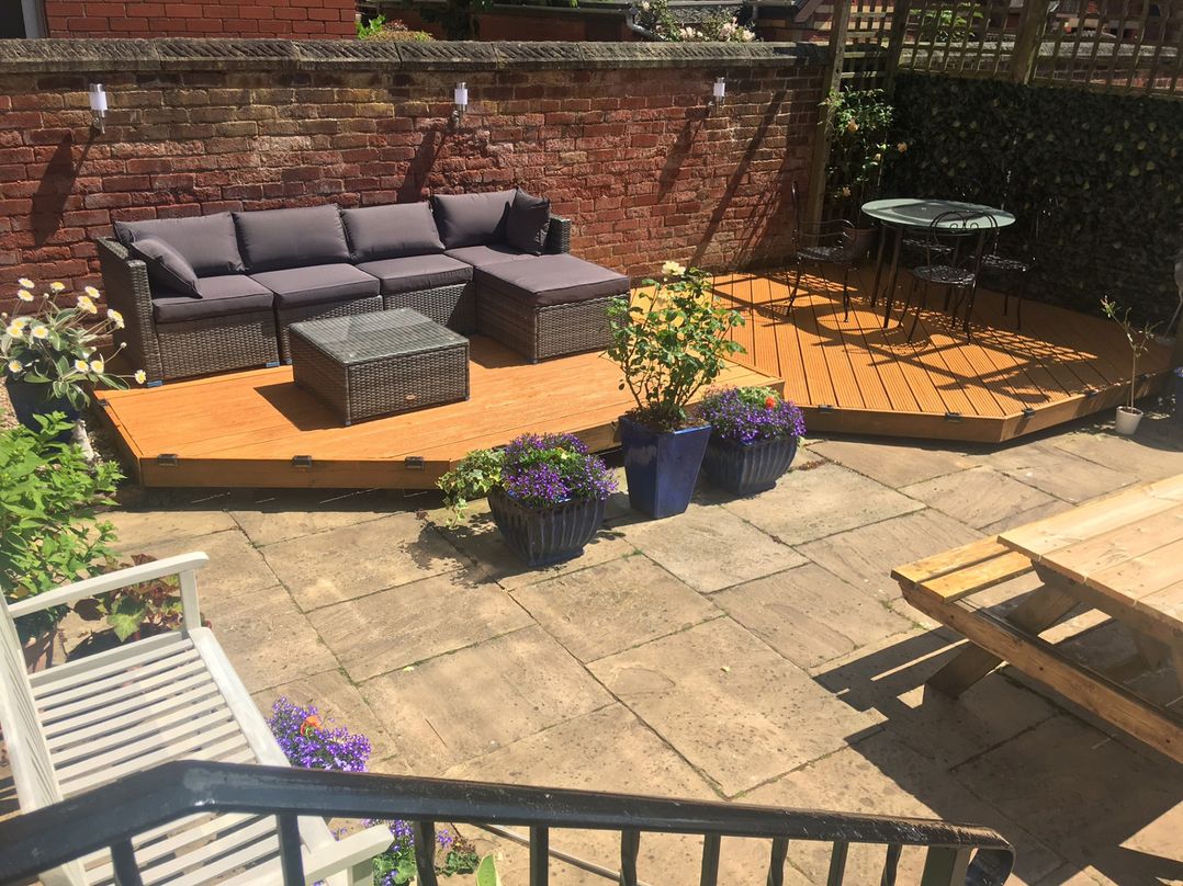 A garden with outdoor seating and flower pots at Apartment 3 in Lytham St. Annes