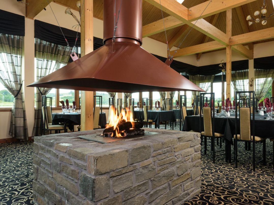 A fireplace with a chimney in a dining room at Sidlaw Spa Fowlis near Dundee