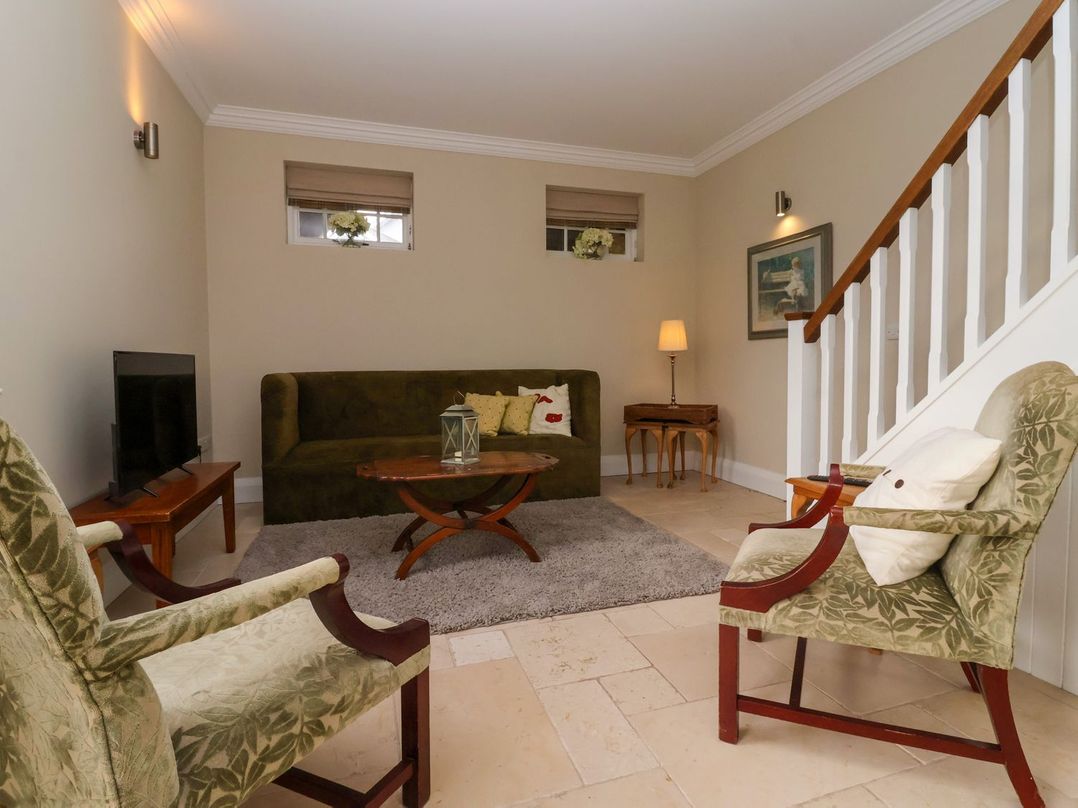 A living room with a sofa, television, and coffee table at The Bothy in Knaresborough