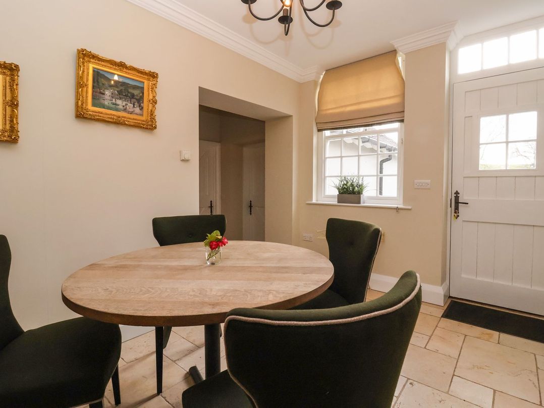 A dining room with a round table and chairs at The Bothy in Knaresborough