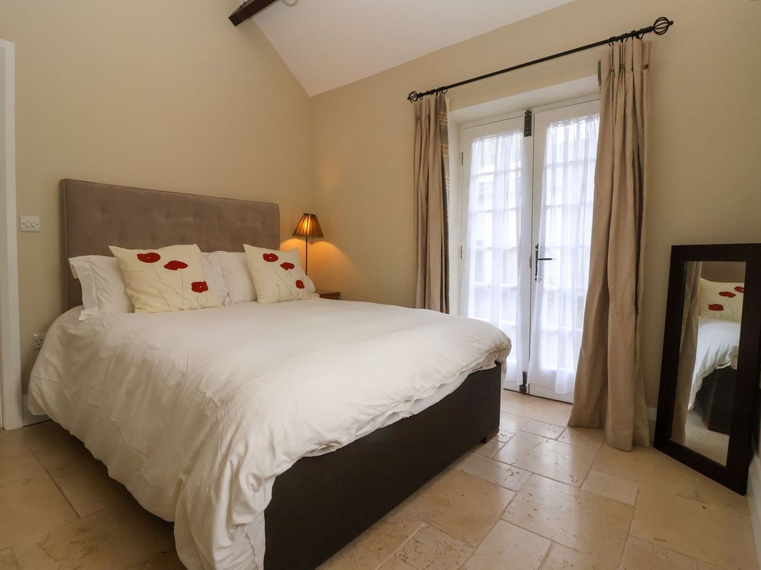 A bedroom with a bed and mirror at The Bothy in Knaresborough