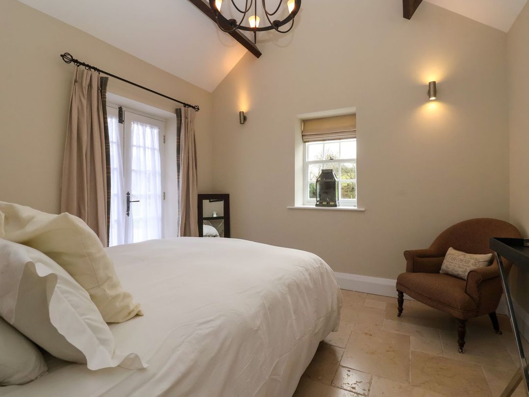 A bedroom with a bed and a chair at The Bothy in Knaresborough