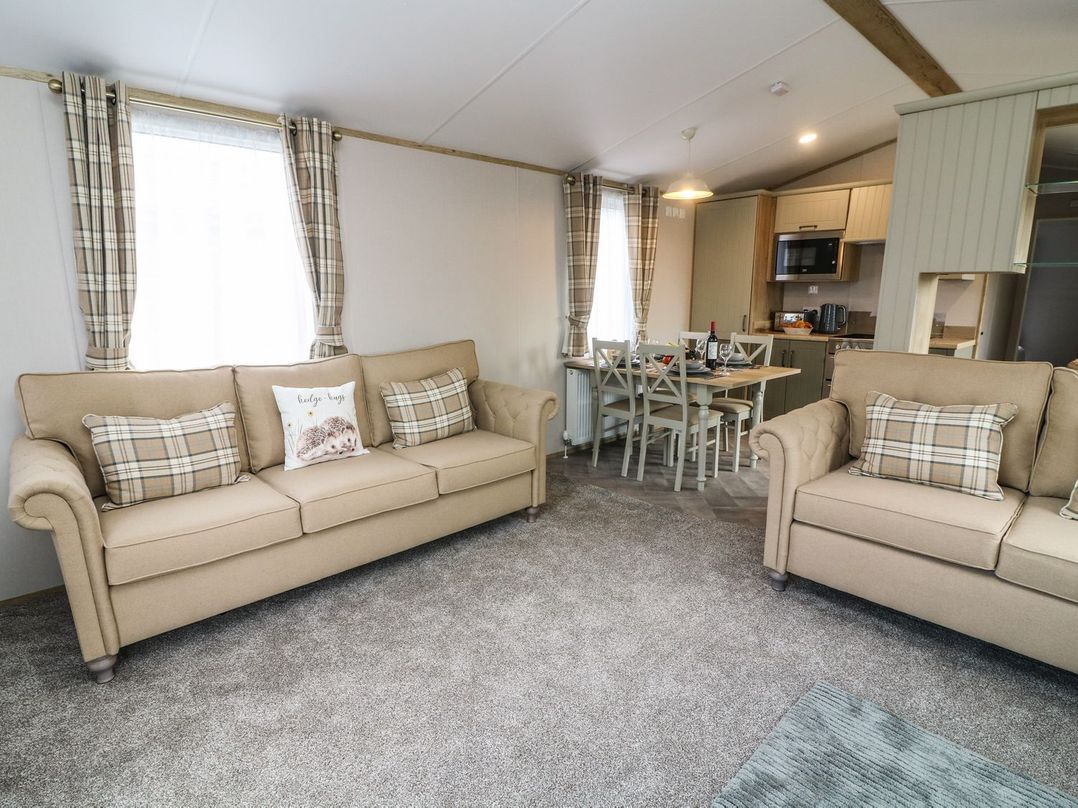 A living room with two sofas and a dining table at Hedgehog Lodge Carnforth