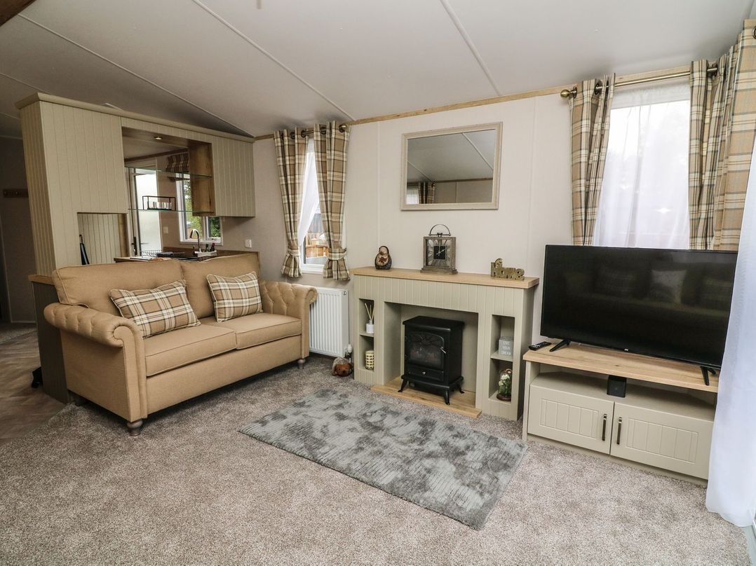 A living room with a sofa and television at Hedgehog Lodge in Carnforth