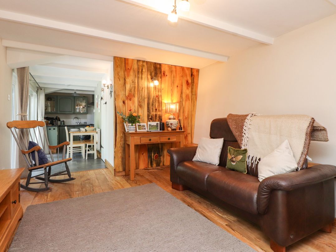 A living room with a sofa and rocking chair at Woodman's Lodge Llanallgo near Moelfre
