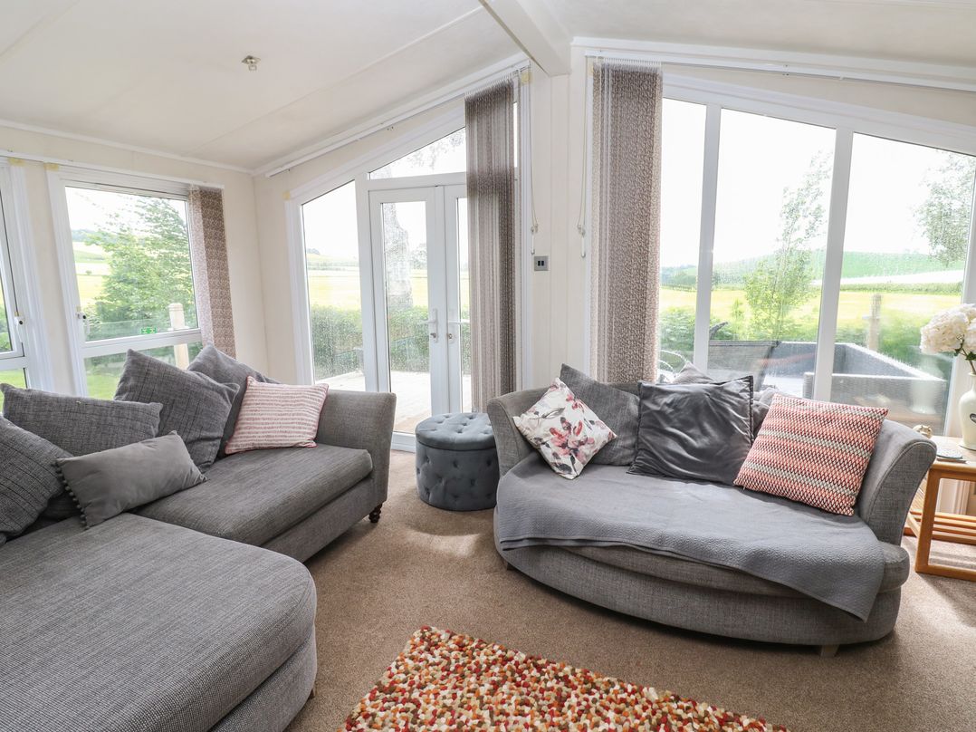 A living room with sofas and large windows at Plot 34 near Armathwaite