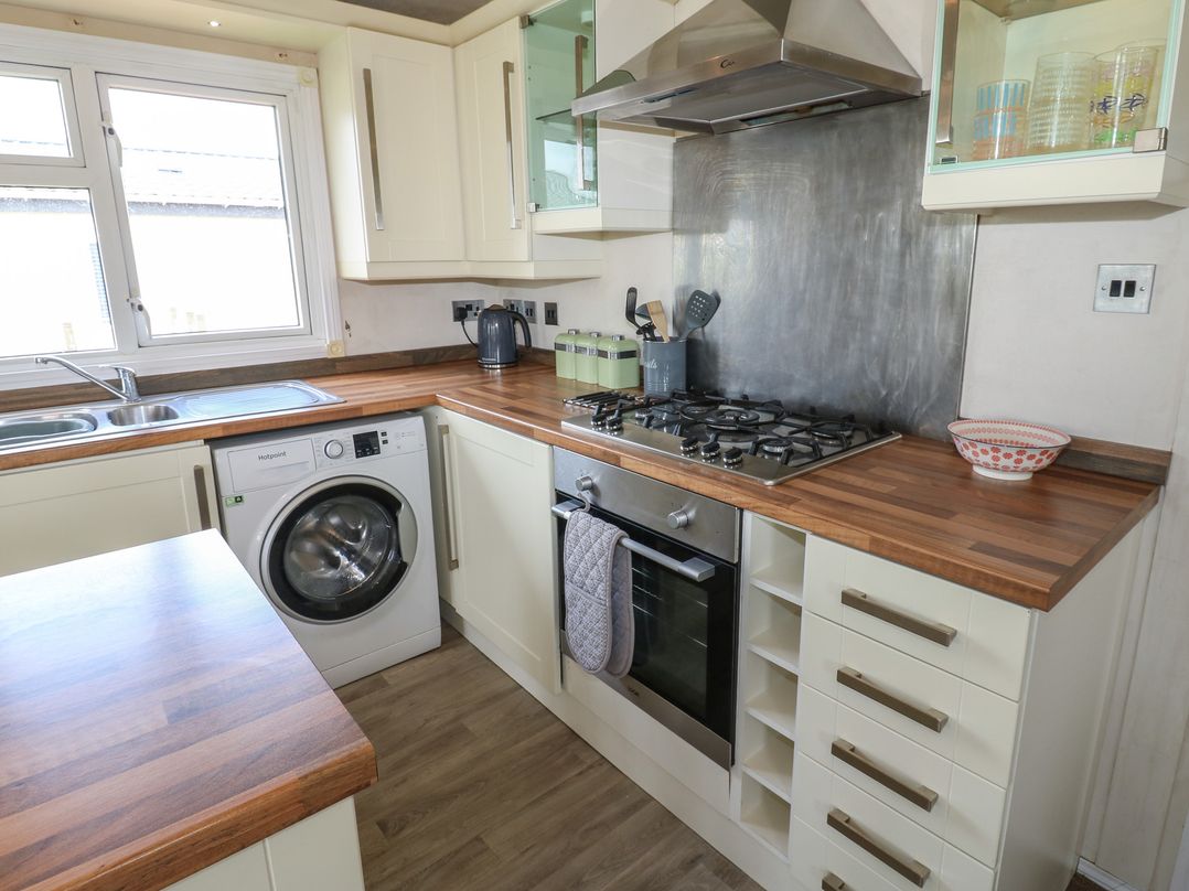 A kitchen with a washing machine and stove at Plot 34 near Armathwaite