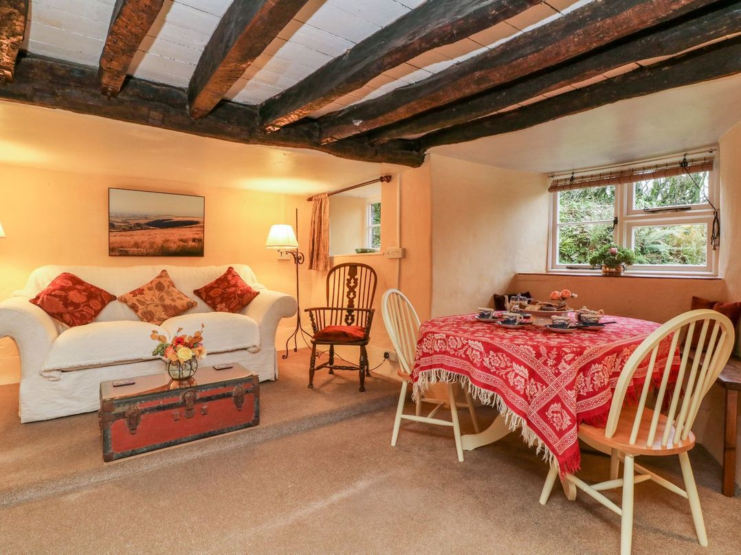 A living room with a sofa and dining table at Whitefield Cottage in Barnstaple