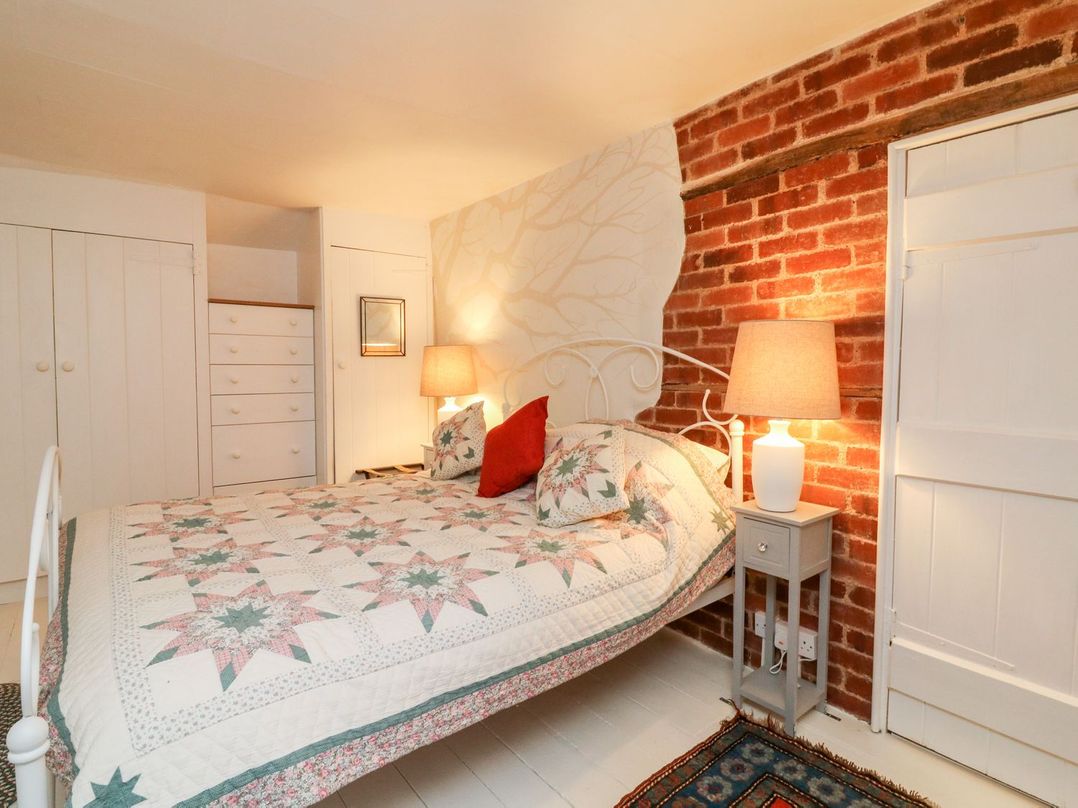 A bedroom with a bed and wardrobe at Whitefield Cottage in Barnstaple