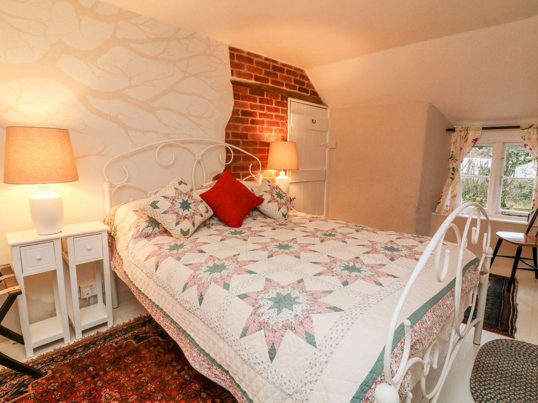A bedroom with a bed and lamps at Whitefield Cottage in Barnstaple