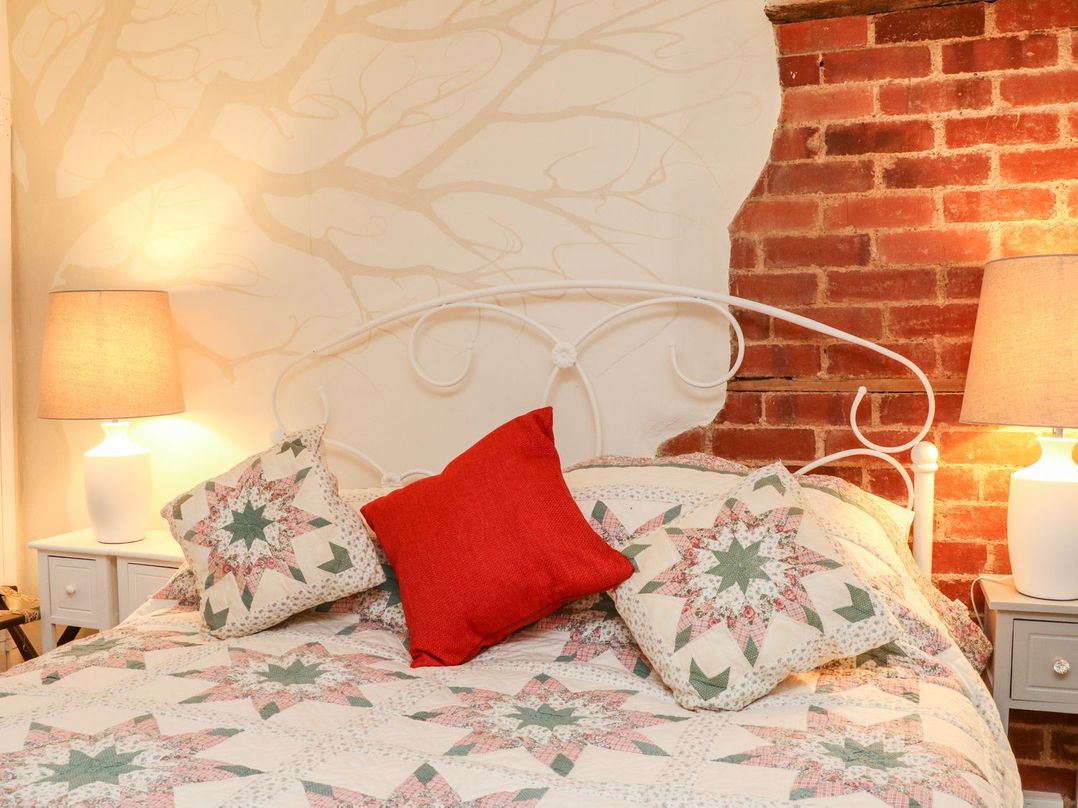A bedroom with a bed and lamp at Whitefield Cottage in Barnstaple