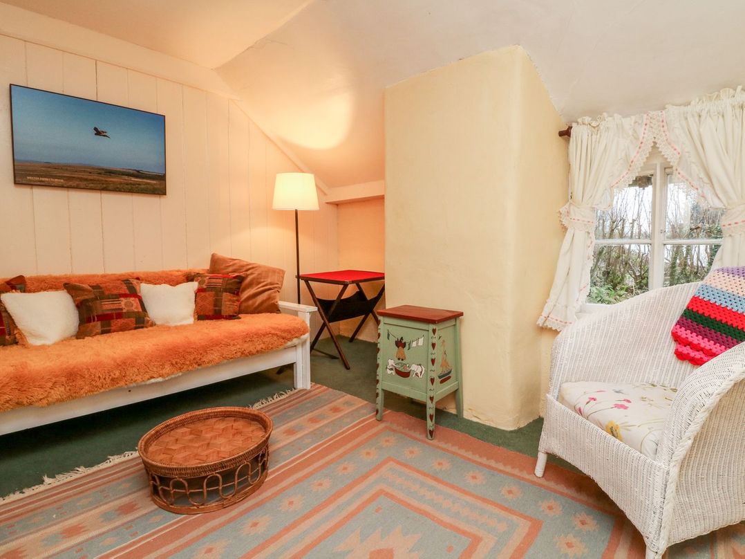 A snug area with a sofa and lamp at Whitefield Cottage in Barnstaple