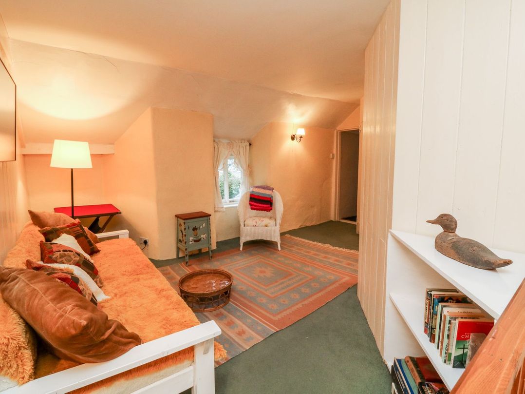 A living room with a sofa and lamp at Whitefield Cottage in Barnstaple