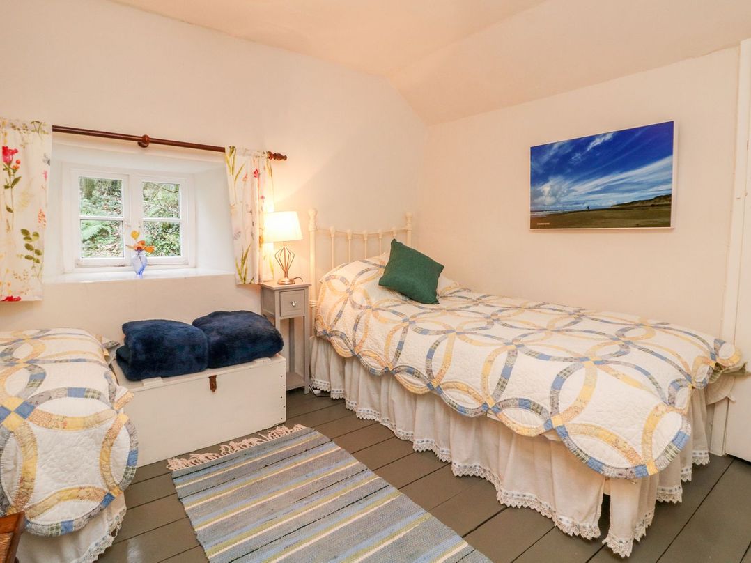 A bedroom with two beds and a window at Whitefield Cottage in Barnstaple