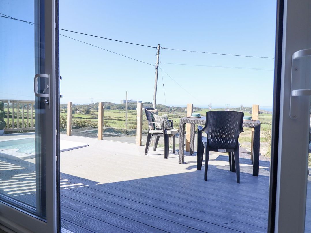 A patio area with an outdoor table and chairs at Posh Pod in Cemaes Bay