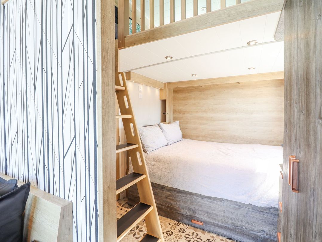 A bedroom with a bunk bed and a ladder at Posh Pod in Cemaes Bay
