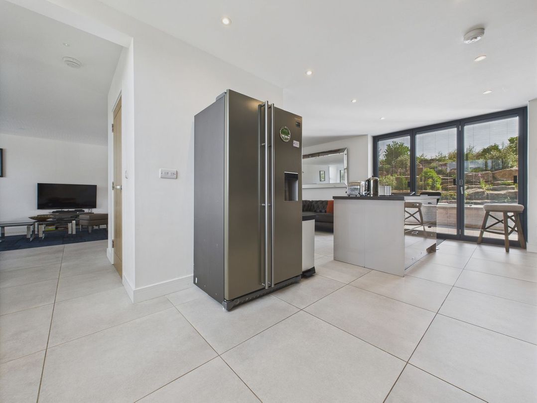A kitchen with a refrigerator and kitchen island at Oakwood House in Tansley near Matlock