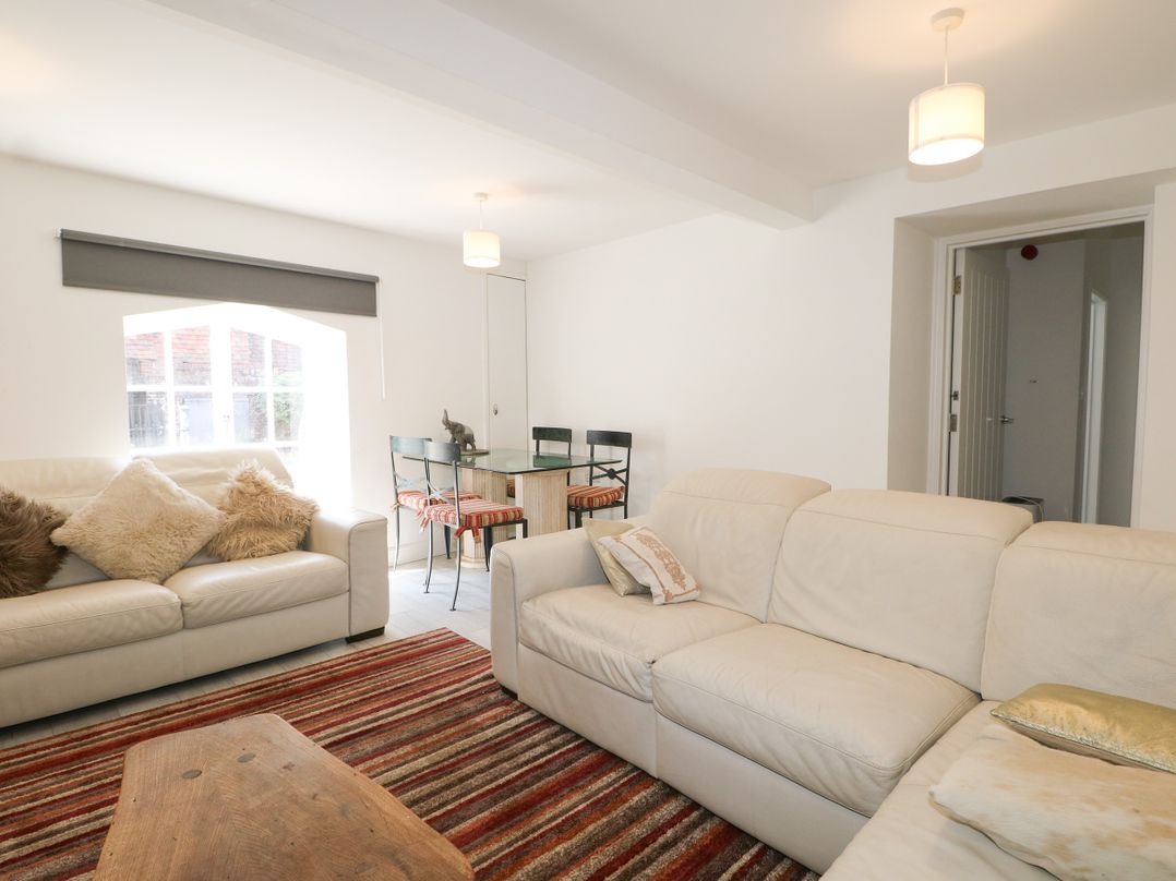 A living room with a sofa and dining table at 2 Bed in Bishop's Waltham