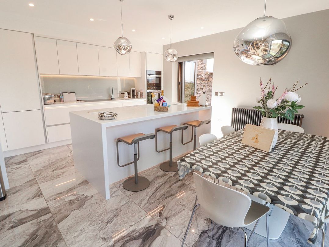 A kitchen with an island and bar stools at Midways in Windermere