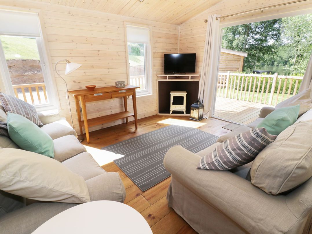 A living room with a television and a wooden table at Kingfisher in Ross-on-Wye