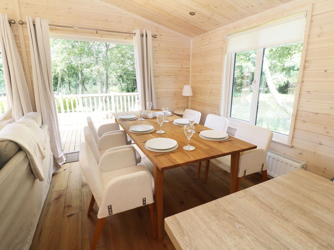 A dining room with a table set for six at Kingfisher in Ross-on-Wye