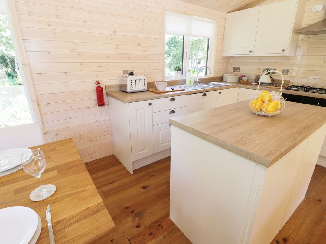 A kitchen with a sink and island at Kingfisher in Ross-on-Wye