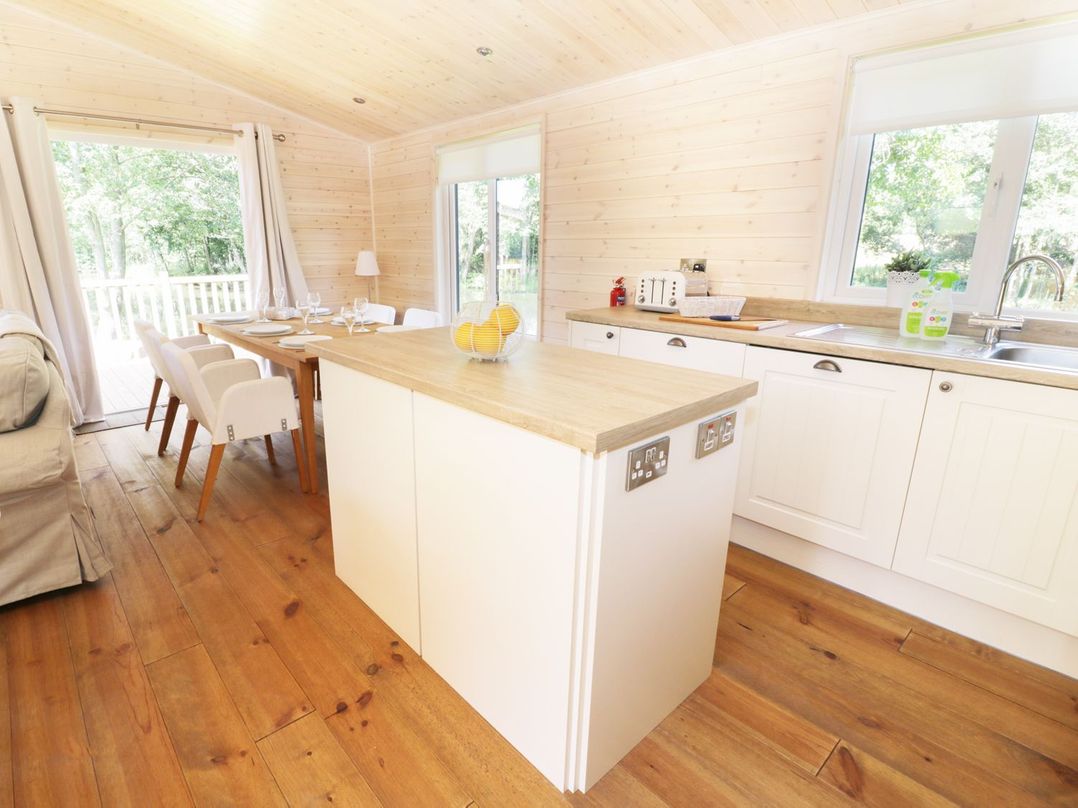 A kitchen with an island and dining table at Kingfisher in Ross-on-Wye