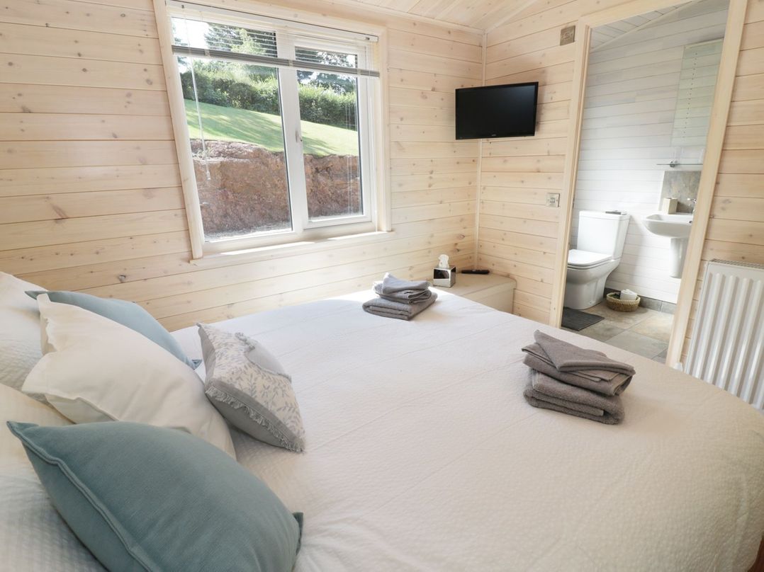 A bedroom with a double bed and ensuite bathroom at Kingfisher in Ross-on-Wye