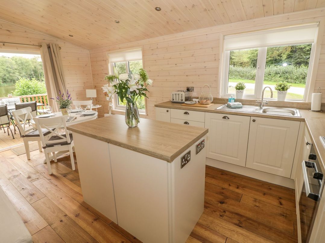 A kitchen with an island and dining area at Mallard in Ross-on-Wye