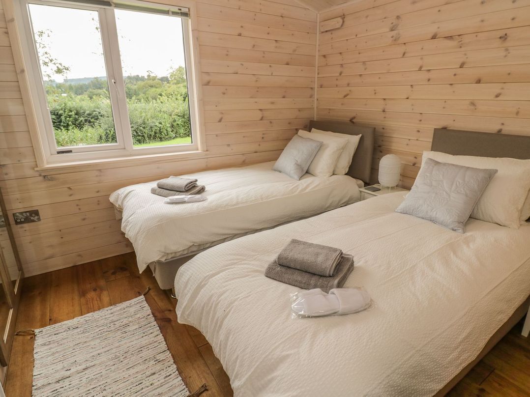 A bedroom with two single beds and a window at Mallard in Ross-on-Wye