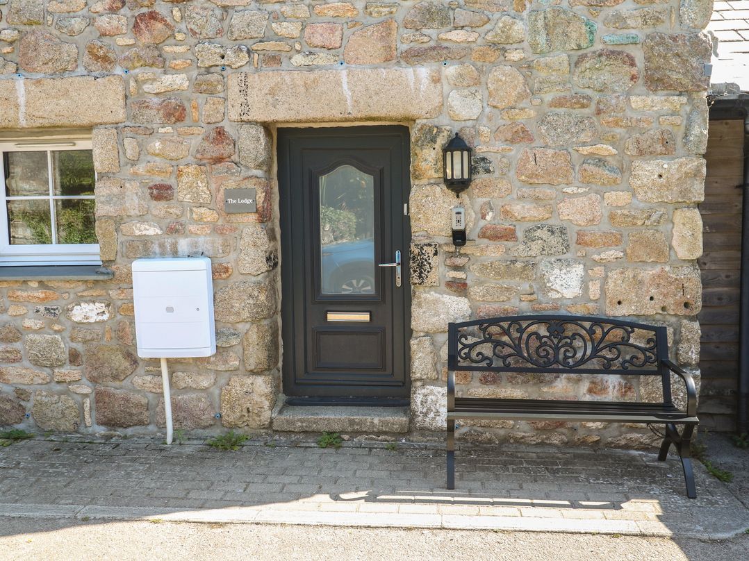An entrance with a door and bench at Gews Farm Lodge in St Just