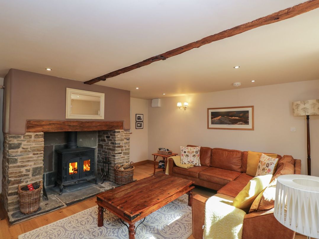 A living room with a fireplace and sofa at The Old Barn in Hereford
