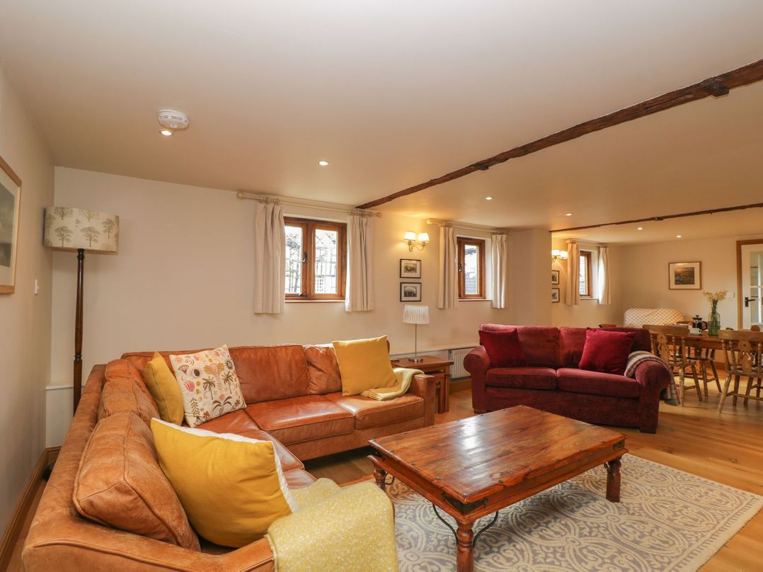 A living room with a sofa and table at The Old Barn in Hereford