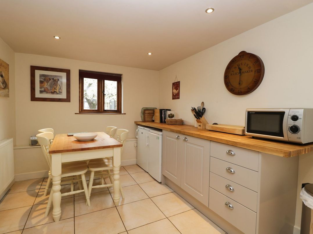 A kitchen with a table and chairs at The Old Barn in Hereford