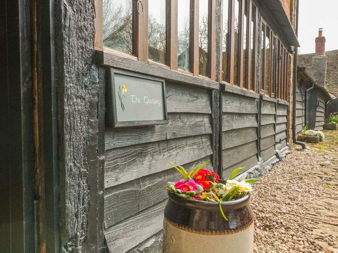 An outdoor area with a sign and flower pot at The Granary in Hereford