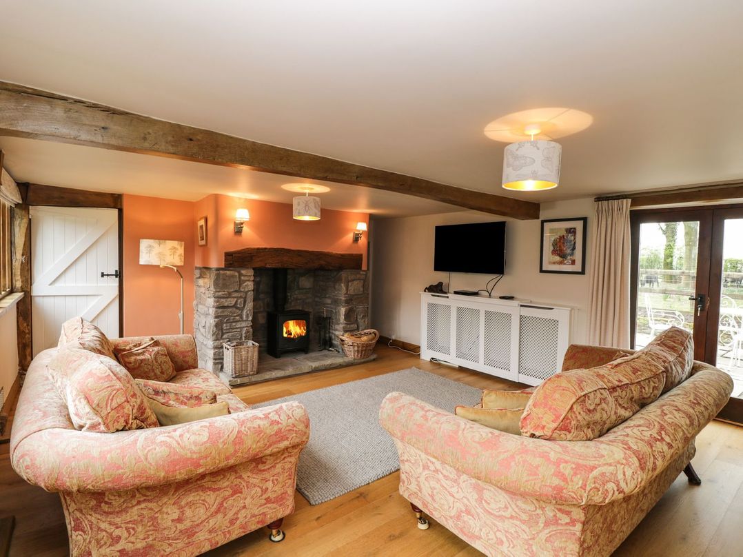 A living room with a fireplace and television at The Granary in Hereford