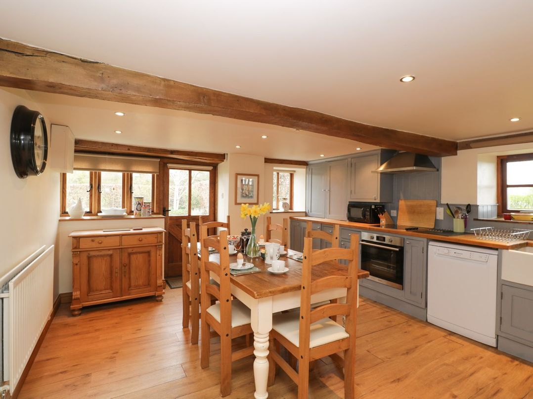 A kitchen with a dining table and chairs at The Granary in Hereford