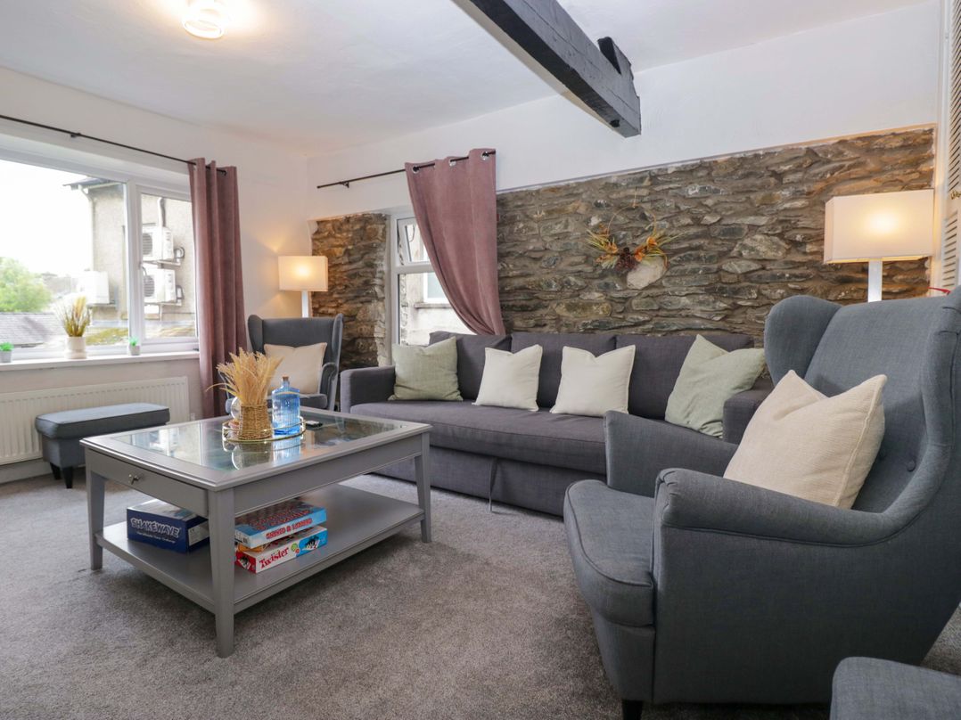 A living room with a sofa and coffee table at Courtyard Cottage in Cartmel